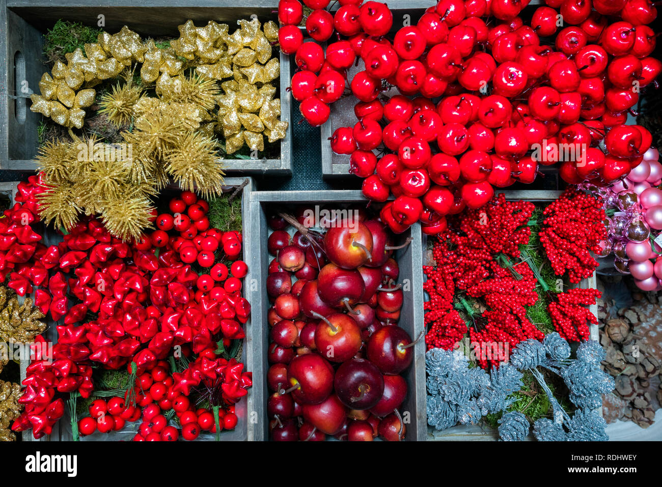 Verschiedene Weihnachtsbaum und Geschenke Dekorationen. Goldene und silberne Tannenzapfen, rote Äpfel Stockfoto