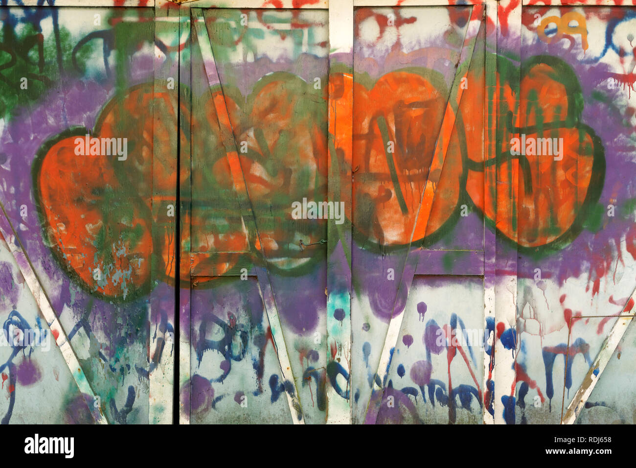 Holz- wand mit lebhaft bunten Tags und anderen städtischen Graffiti, abstrakte Design lackiert Stockfoto
