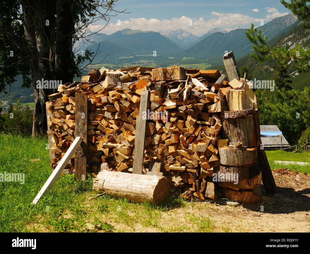 Gestapeltes Holz Stapel mit Tal und die Berge dahinter, Tirol, Österreich Stockfoto