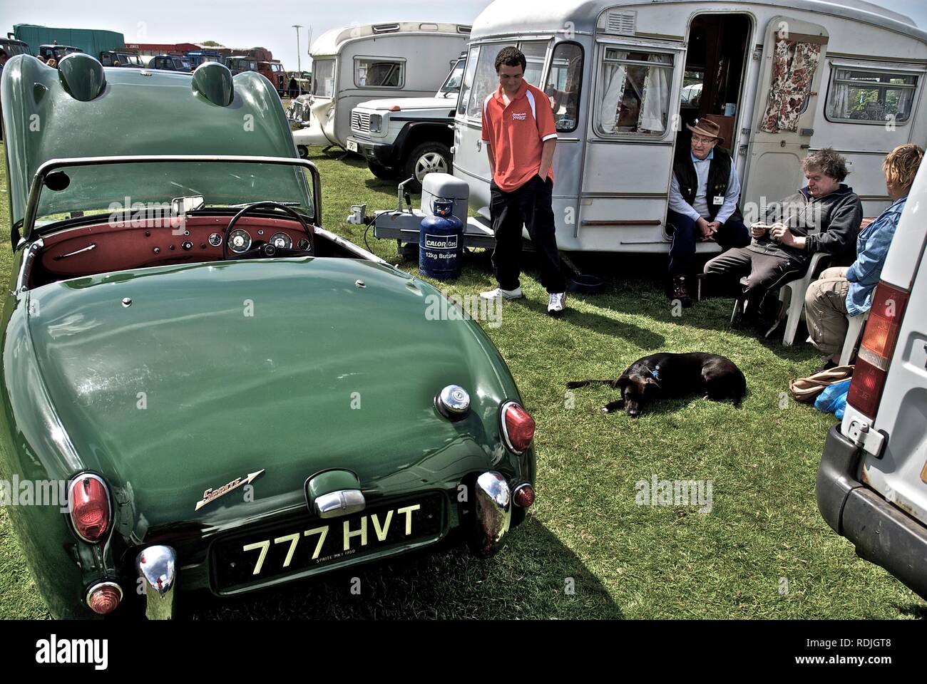 Ein vintage Austin Healey Mk1 Frogeye' Sprite Sportwagen mit seinem Besitzer an der Oldtimer Rallye, Anglesey Anglesey, North Wales, UK, Mai 2010 Stockfoto