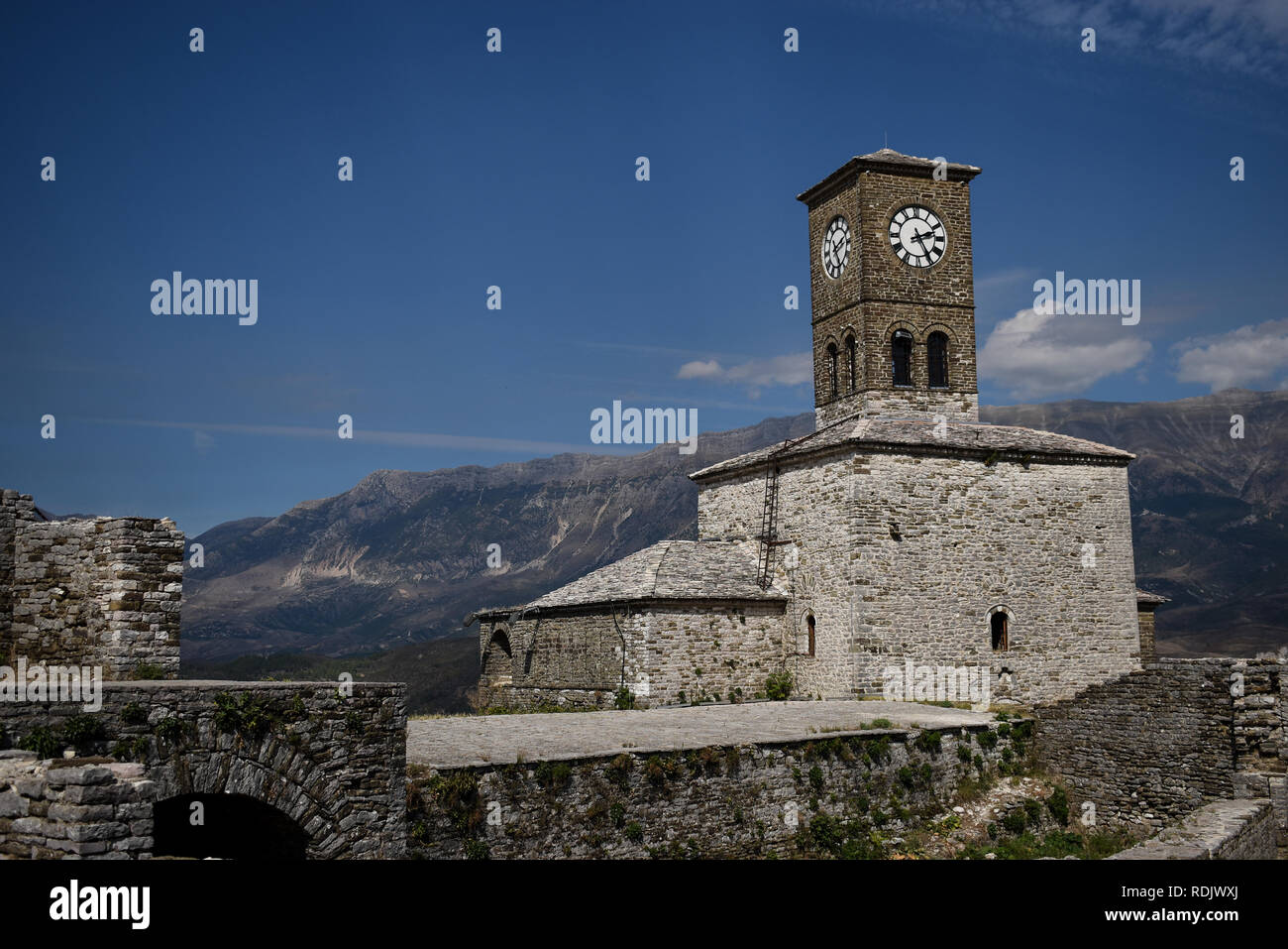 Old Clock Tower aus Stein mit Bergen im Hintergrund Stockfoto