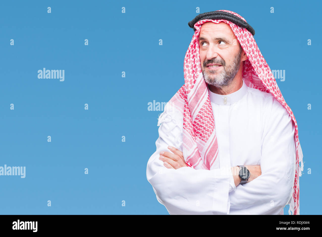 Senior arabischen Mann mit kufiya über isolierte Hintergrund lächelnd Seite suchen und sie starrte Denken. Stockfoto