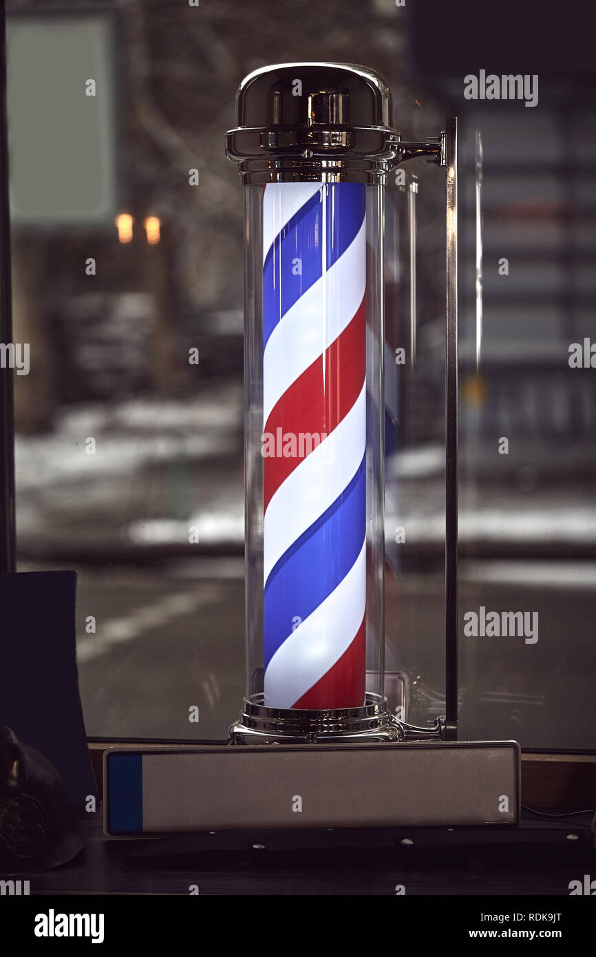 Der Friseur. Das berühmte Symbol für einen Friseur mit wirbelnden roten, blauen und weißen Streifen. Stockfoto