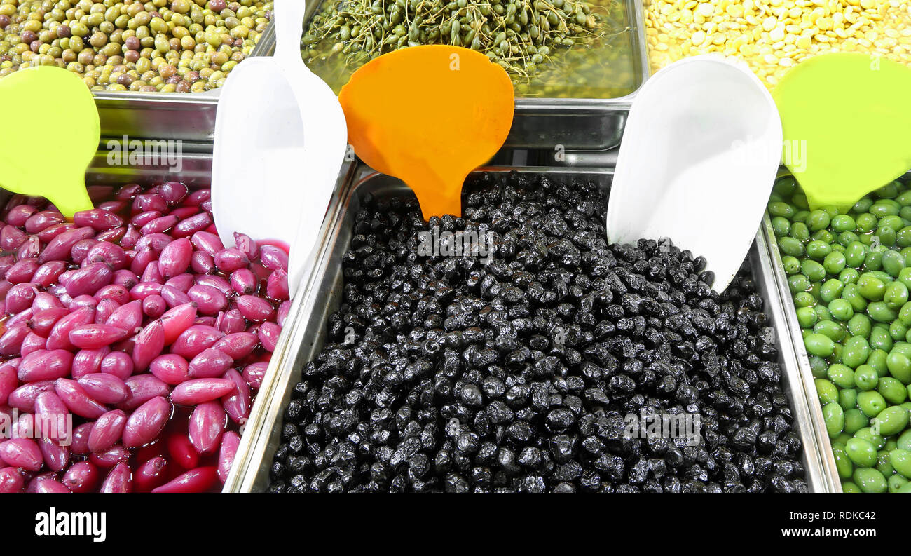 Fach mit schwarzen und grünen Oliven und andere organische Produkte wie rote Zwiebeln zum Verkauf gefüllt in der Marktstand eines mediterranen Land Stockfoto