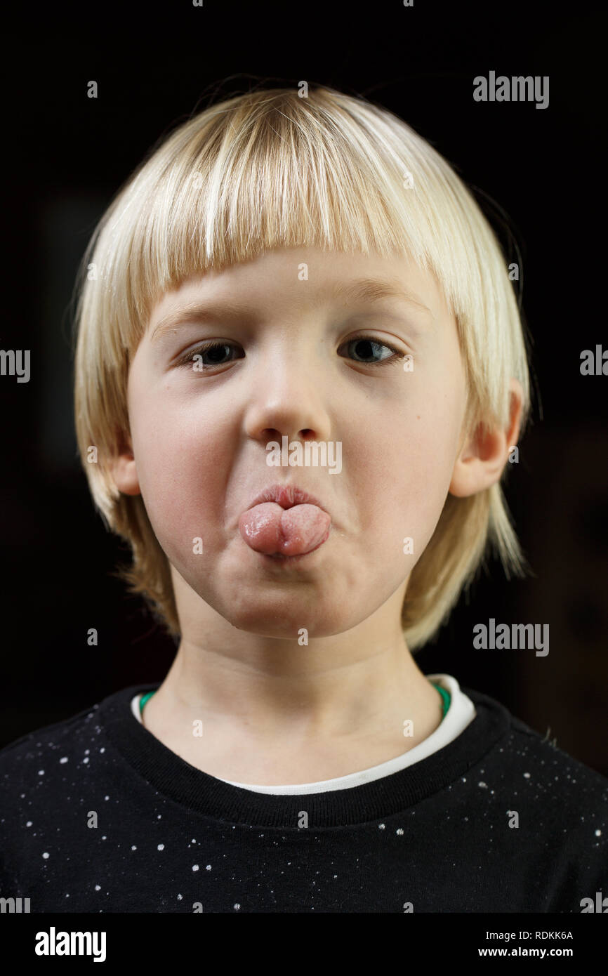 Willensstark kleiner Junge, freche, seine Zunge zu zeigen. Verspielte Kindheit, little Rebel, eigensinnig, stur Kind Konzept. Stockfoto