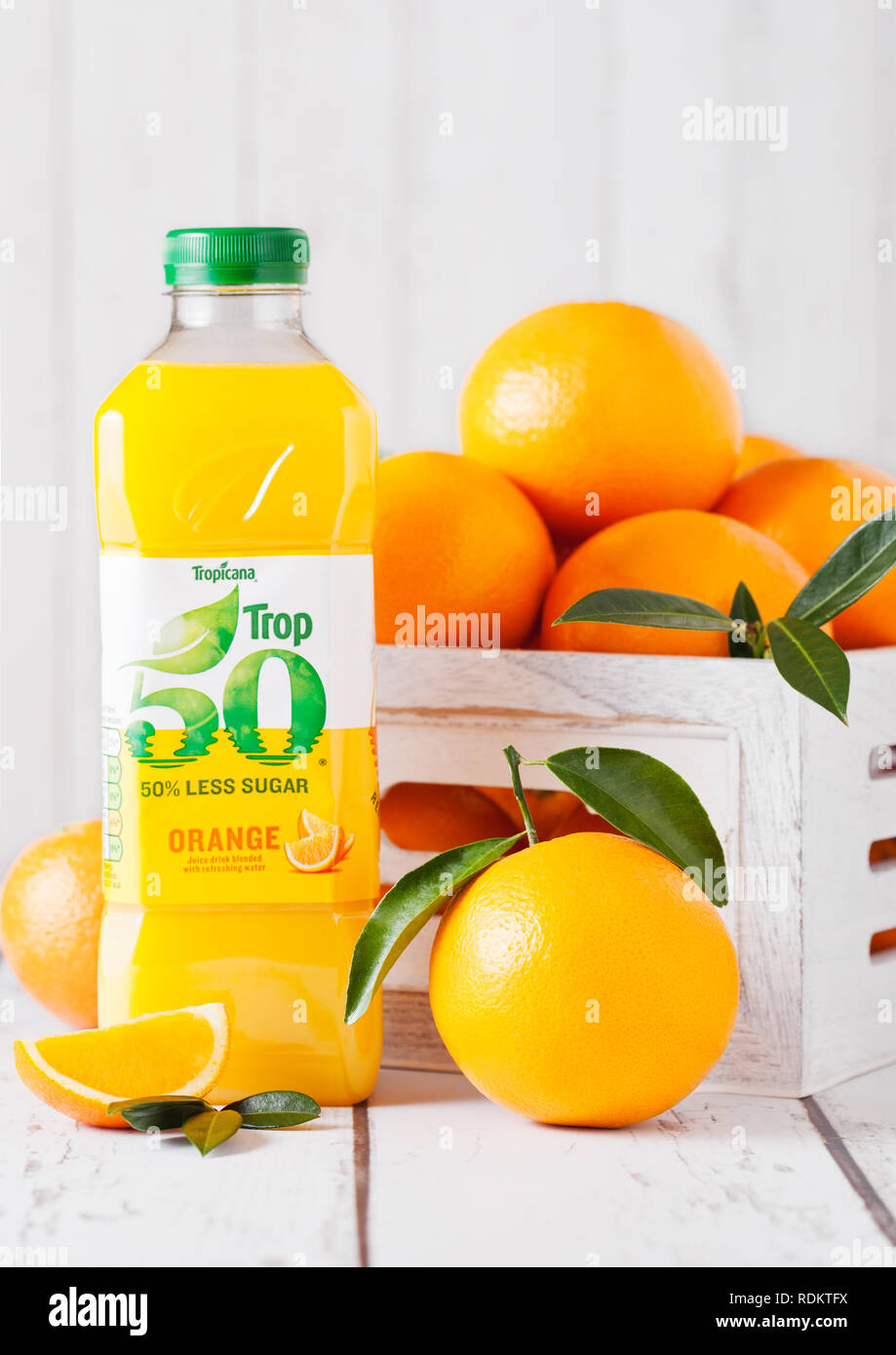 LONDON, Großbritannien - 15 Januar, 2019: Kunststoff Flasche frischen tropischen Tropicana Orangensaft mit frischen, rohen Orangen in weißen Holzkiste. Stockfoto