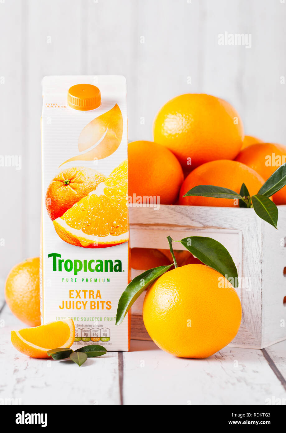 LONDON, Großbritannien - 15 Januar, 2019: Pack von frischen tropischen Tropicana Orangensaft mit frischen, rohen Orangen in weißen Holzkiste. Stockfoto