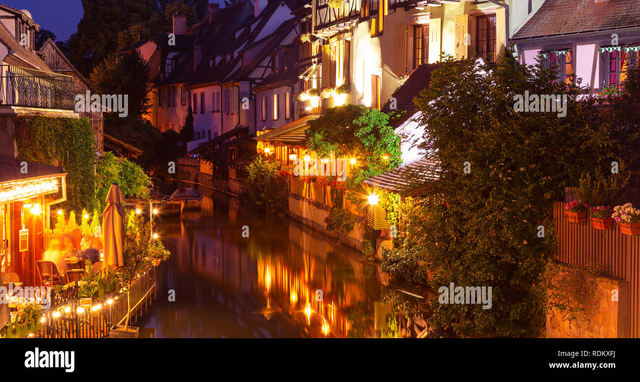 Alte Häuser beleuchtet, kleiner Fluss, Wasser Reflexion in der Nacht im Frühling, Colmar, Frankreich. Stockfoto