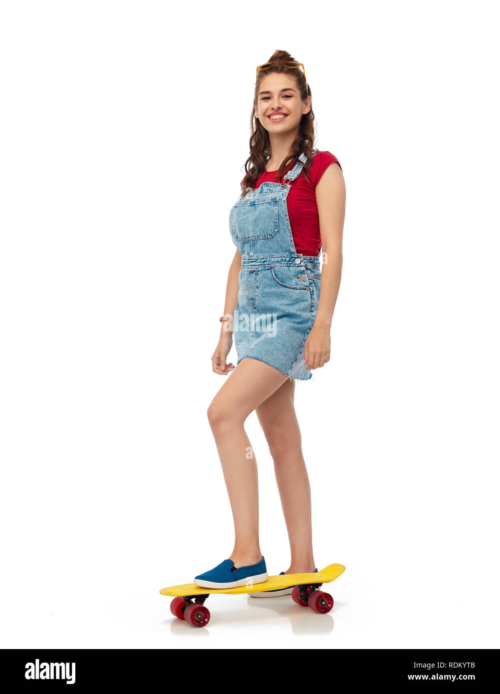 Smiling teenage Mädchen mit Skateboard über Weiß Stockfoto