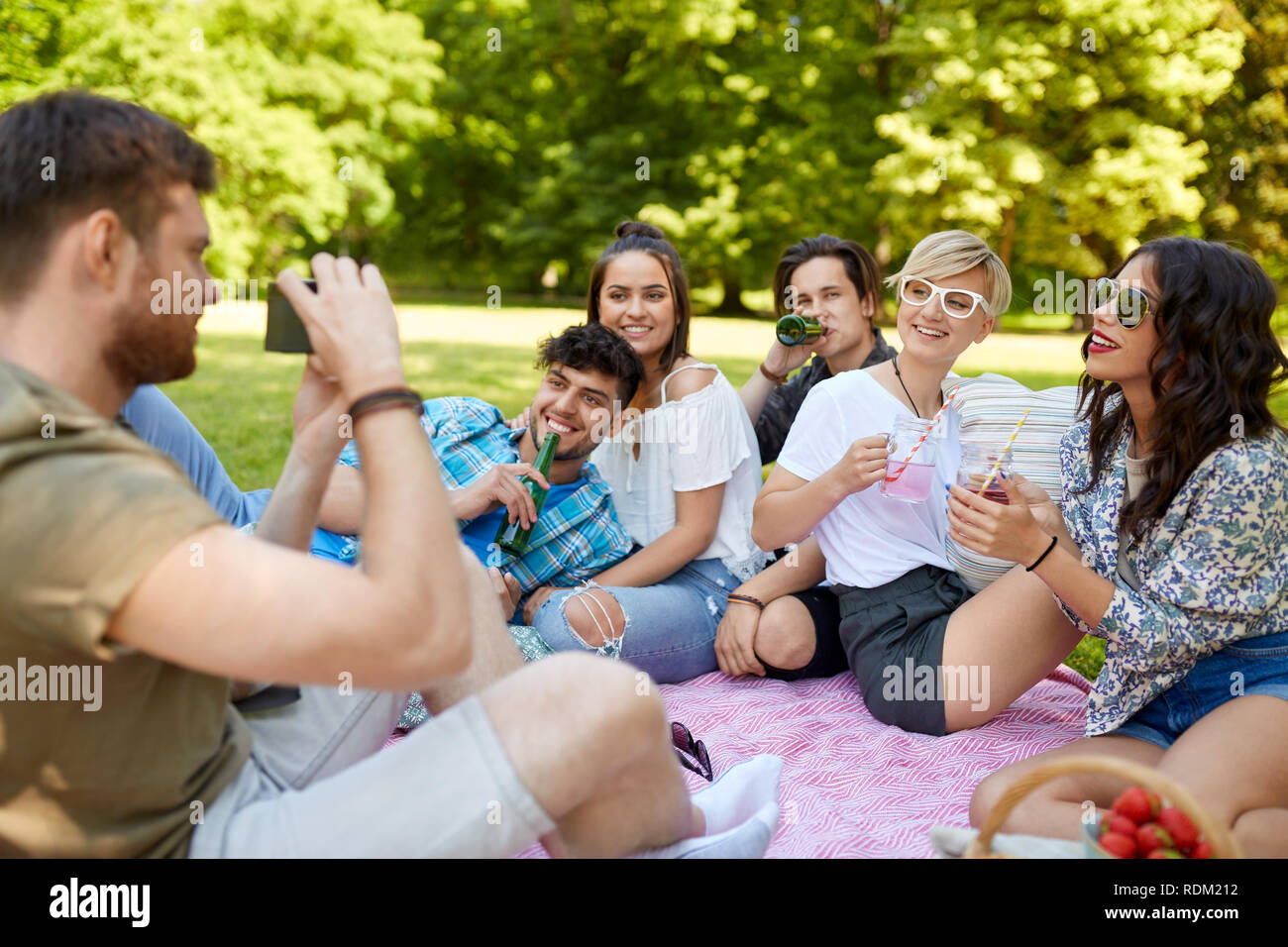 Freunde mit Getränken fotografieren im Sommer Picknick Stockfoto
