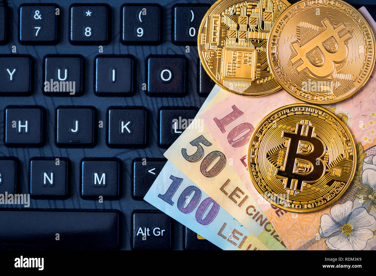 Metall Bitcoins und rumänischen Geld (Ron, neue Lei) über die Tastatur. Konzept der neuen virtuellen Geld Währung. Stockfoto