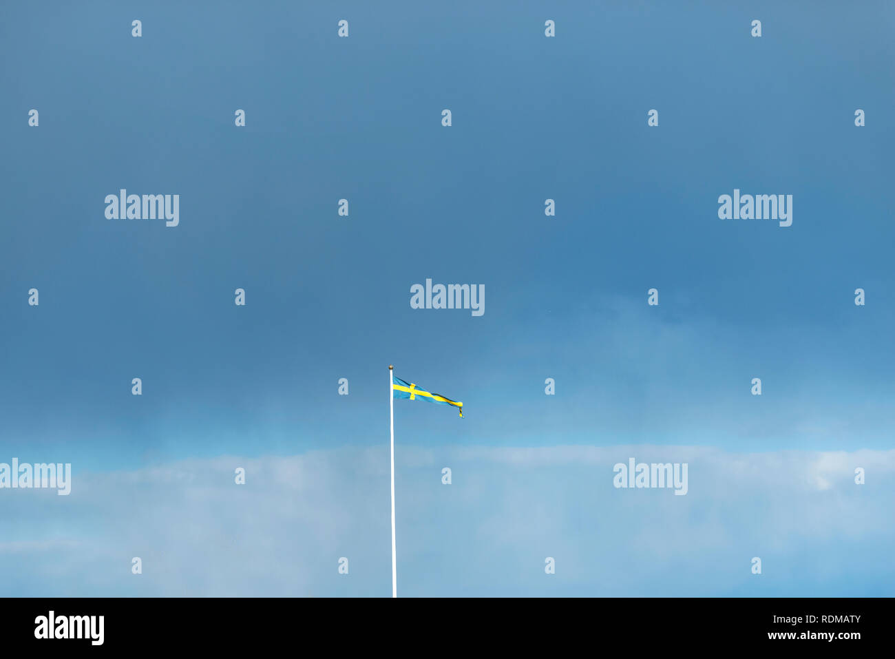 Schwedische Flagge gegen blauen Himmel Stockfoto