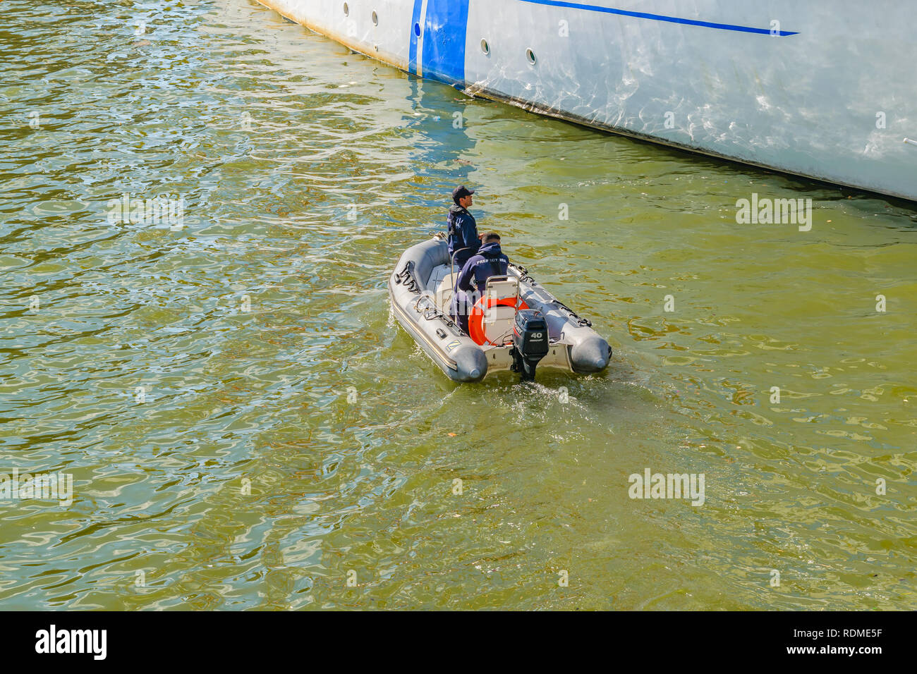 MONTEVIDEO, URUGUAY, APRIL 2018 - zwei Männer auf aufblasbaren Boot zur Unterstützung ein Schiff im Hafen. Stockfoto