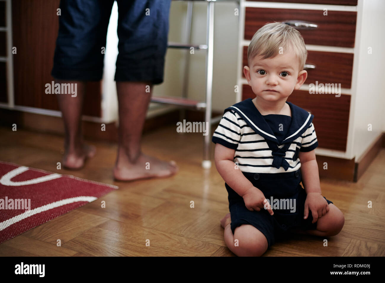 Baby boy in Richtung Hartholz Boden zeigen Stockfoto