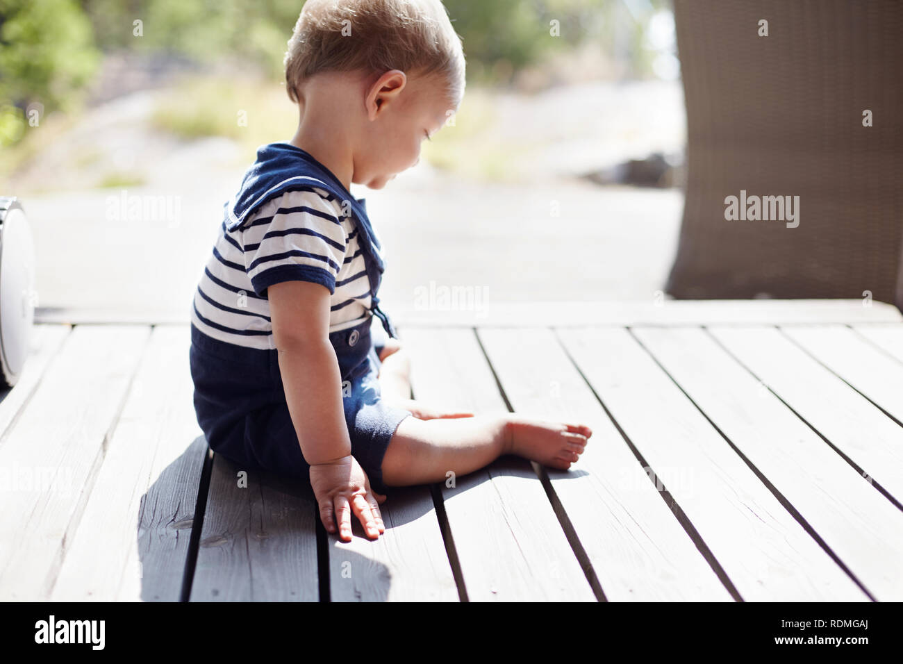 Baby Junge sitzt auf der Veranda Stockfoto