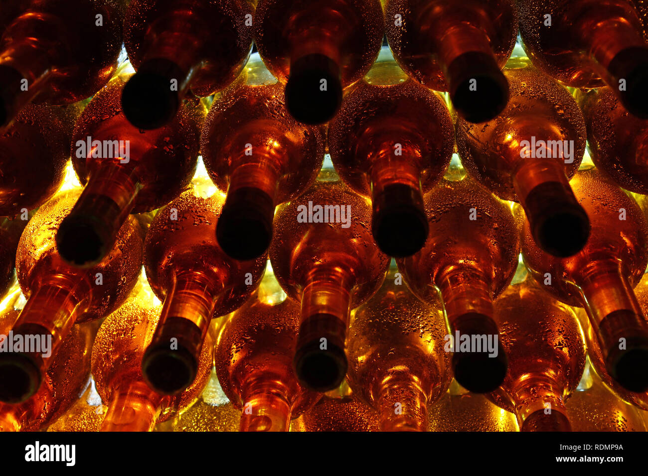 In der Nähe von Zeilen mit Hintergrundbeleuchtung Weißwein Glas Flaschen gestapelt Altern im Weingut Keller Stockfoto