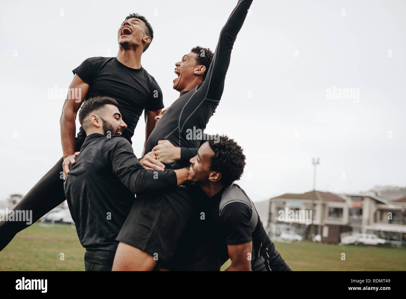 Aufgeregt Fußballspieler in Freude schreien nach dem Scoring ein Ziel. Mannschaftskameraden feiern Sieg halten der Torschütze. Stockfoto