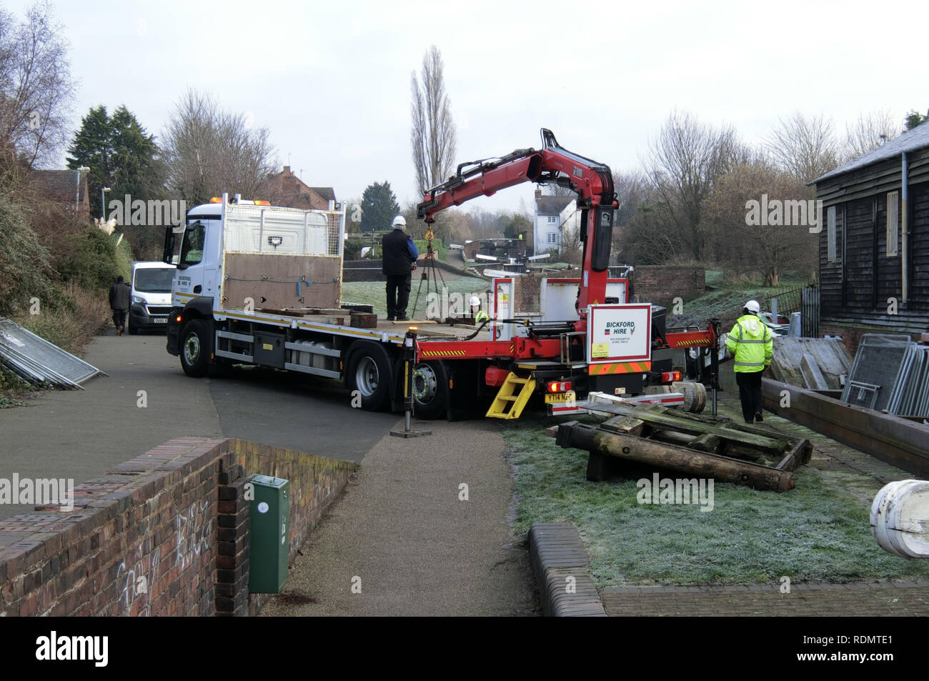Flaches Bett Lkw mit hydraulischen Arm Hebezeuge Arbeiten zum Austausch der Schleuse Tore mit Arbeitern, Stourbridge Canal, West Mids, England, Großbritannien im Winter Stockfoto