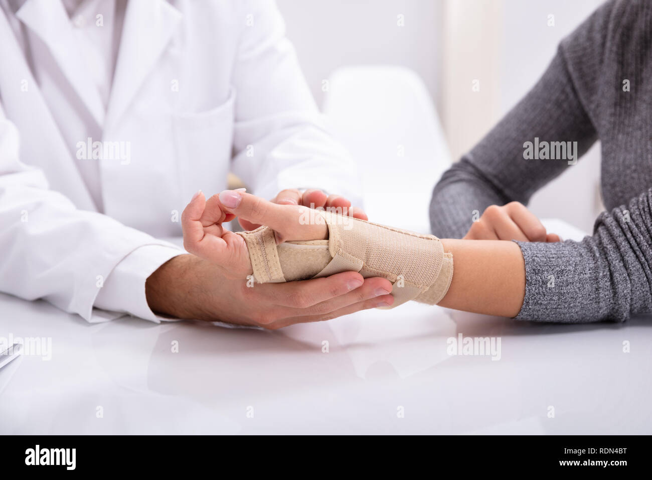 In der Nähe des Doctor's Hand Kontrolle der gebrochenen Hand einer Frau Stockfoto