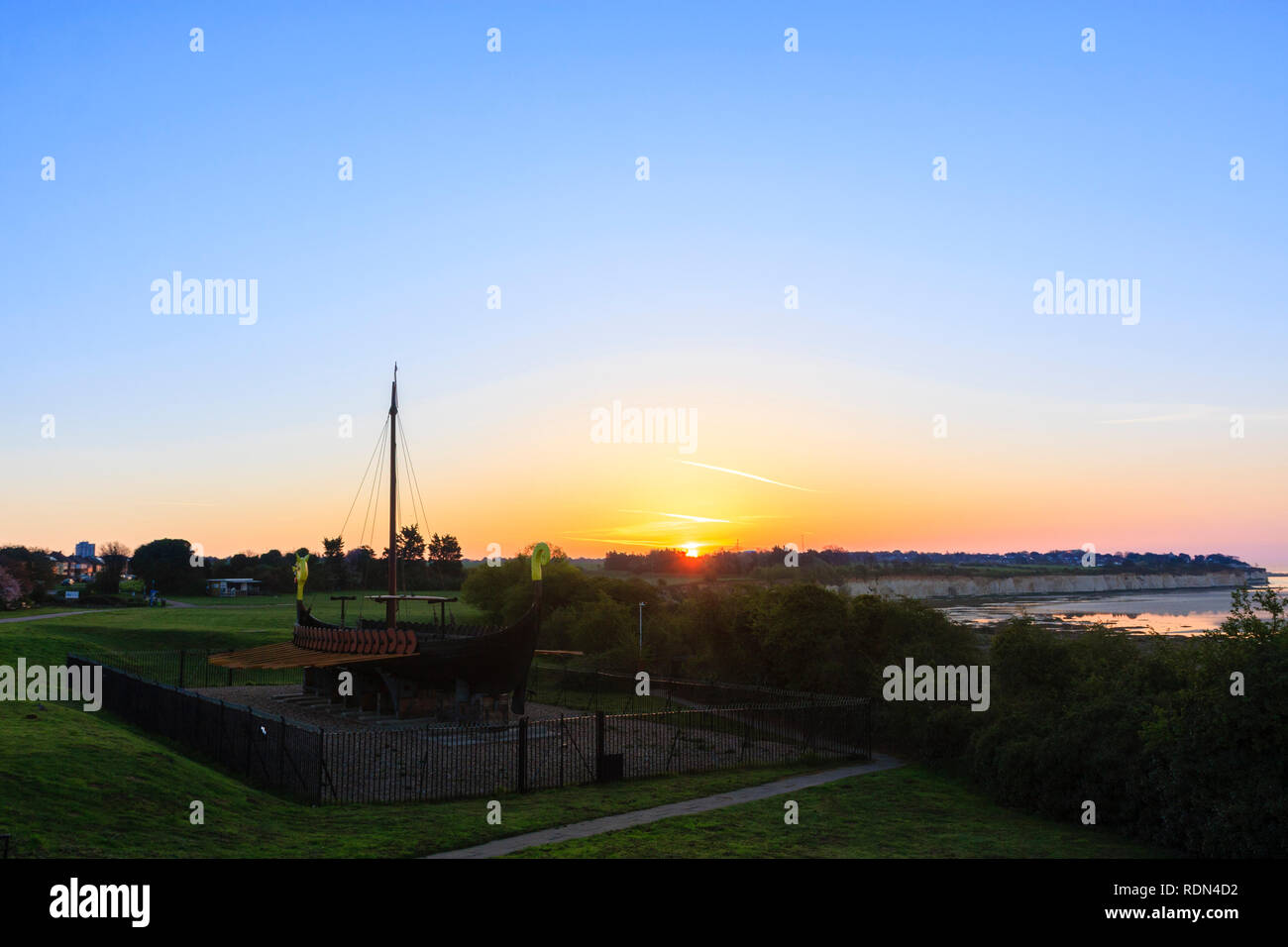 Sonnenaufgang über Ramsgate aus pegwell's Bay Viking Schiff gesehen. Blauer Himmel mit dünnen Band von Orange am Horizont. Kreidefelsen und die Bucht bei Ebbe. Stockfoto