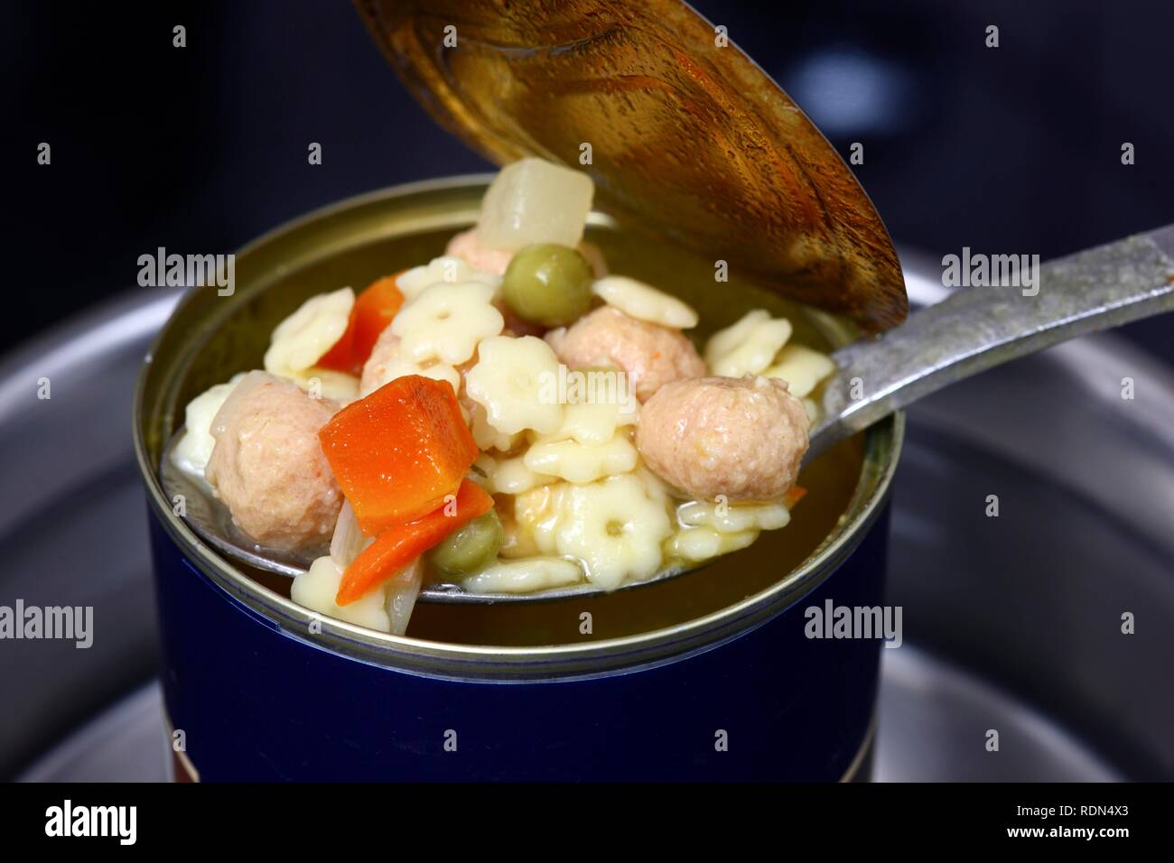 Nacherwärmung ein fertiggericht in eine Blechdose im Wasserbad, Nudelsuppe mit Frikadellen und Gemüse Stockfoto