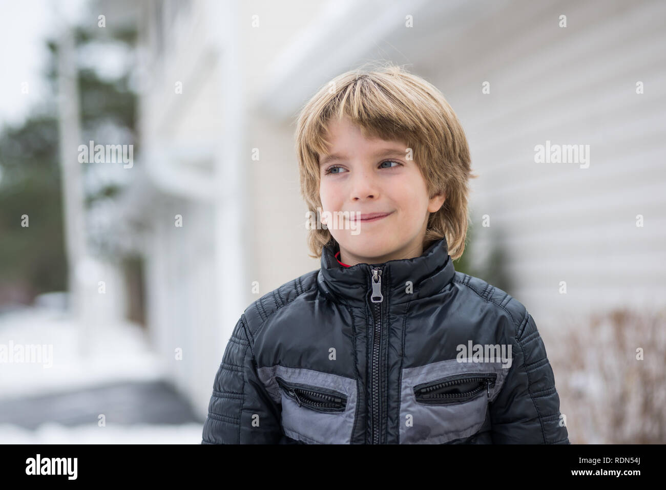 Porträt eines lächelnden Jungen mit einem unscharfen Hintergrund in einem Winter Stockfoto