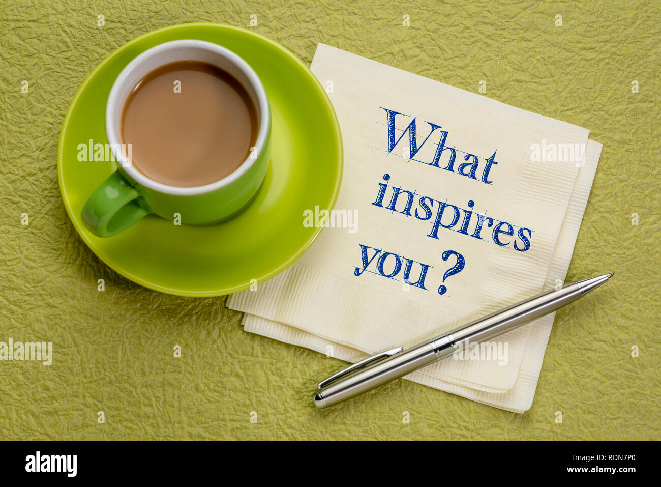 Was inspiriert Dich? Handschrift auf eine Serviette mit einer Tasse Kaffee Stockfoto
