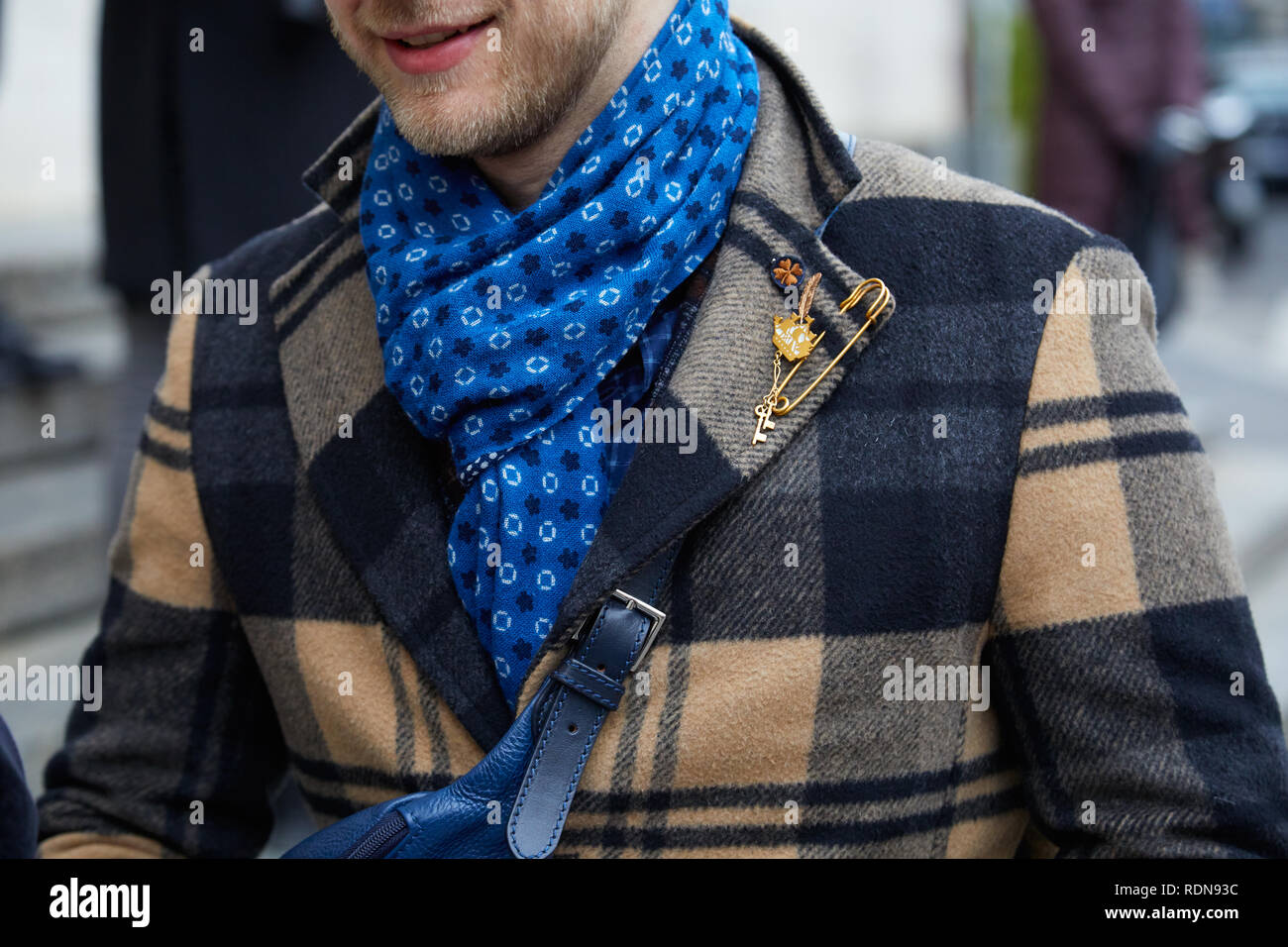 Mailand, Italien - Januar 12, 2019: Der Mann mit dem blauen Schal, beige  und schwarz karierten mantel und goldene Brosche, bevor Frankie Morello  fashion show, Mailand Fash Stockfotografie - Alamy