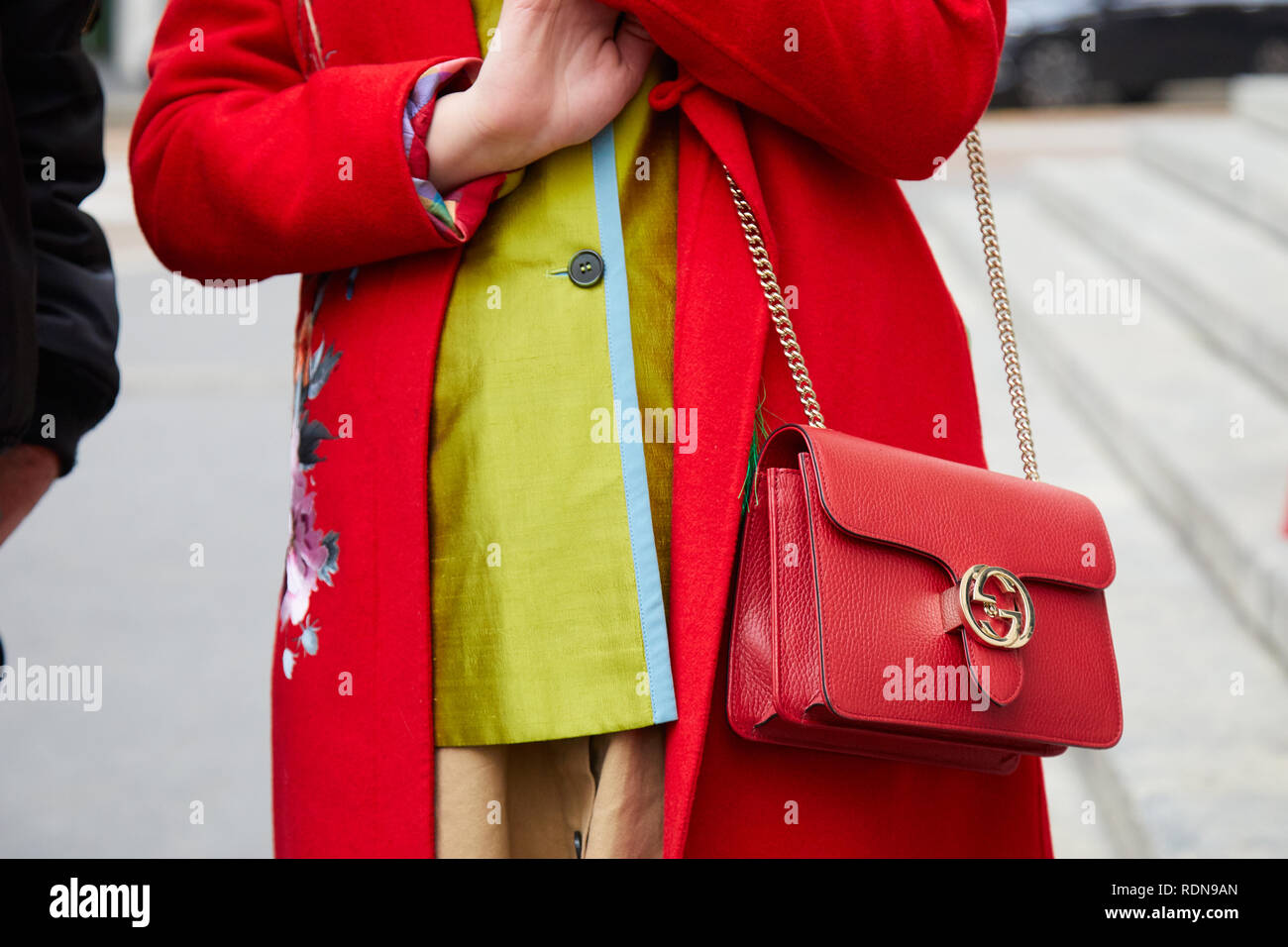 Mailand, Italien - Januar 12, 2019: Frau mit roten Mantel und Gucci Ledertasche mit goldenen Kette vor dem Dolce & Gabbana fashion show, Mailand Fashion Week s Stockfoto
