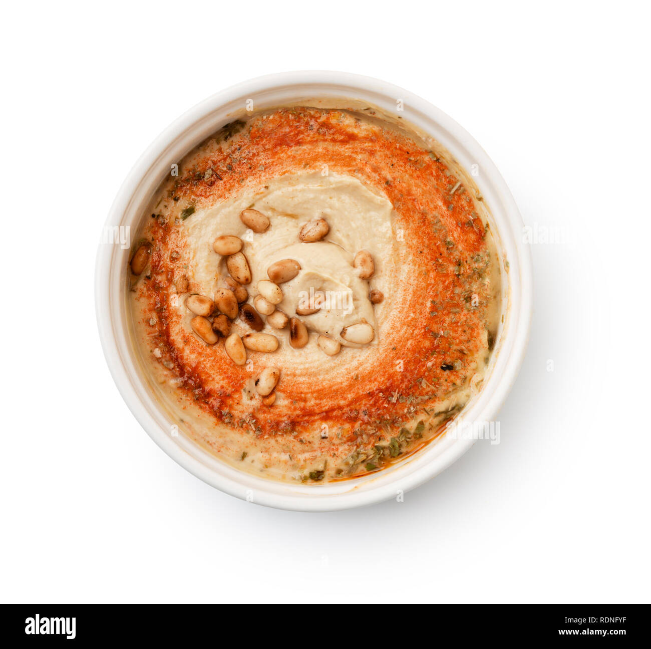 Blick von oben auf die Hummus mit Pinienkernen in Schüssel isoliert auf weißem Stockfoto