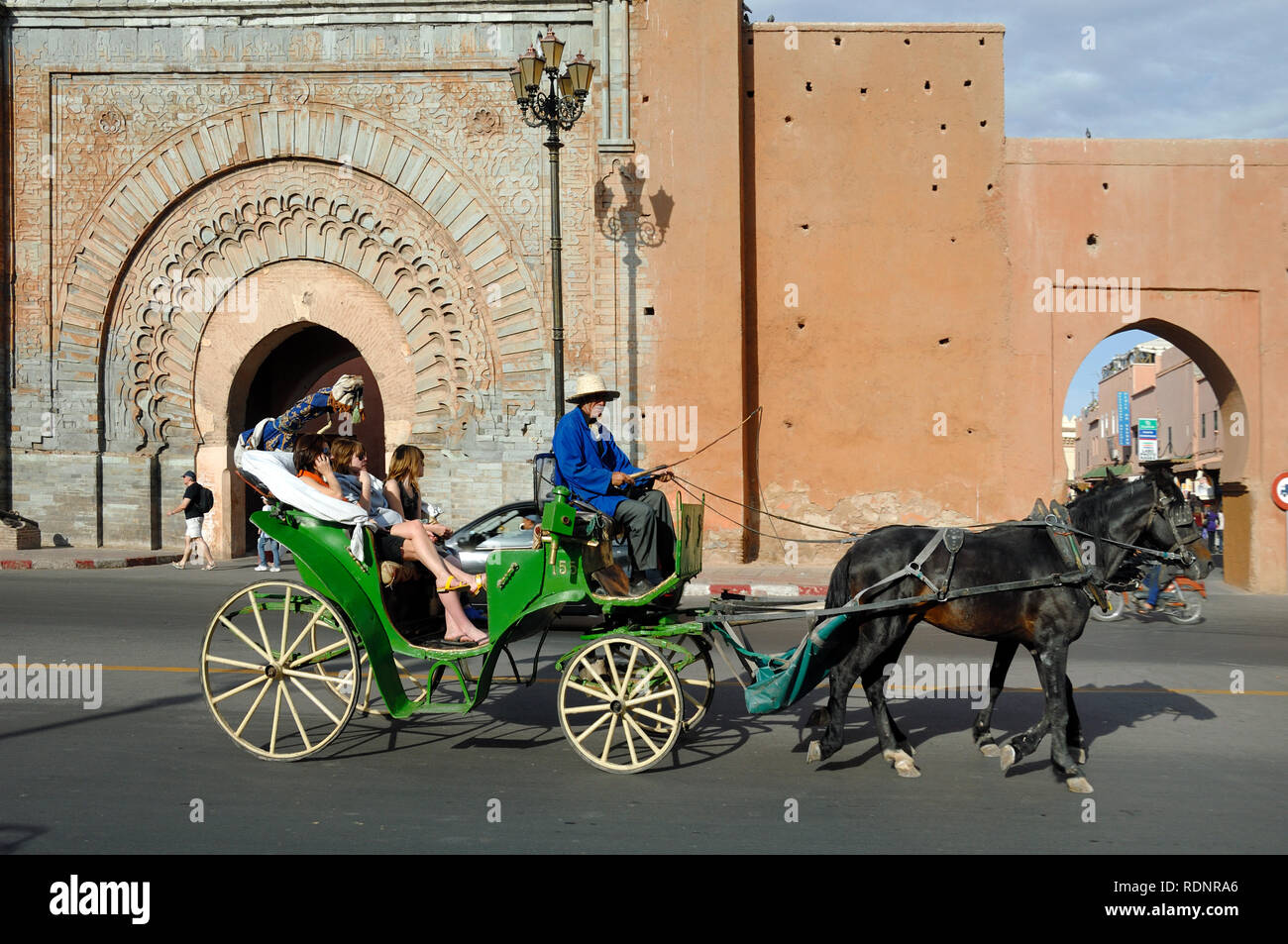Touristen, die eine Tour in einer Kutsche vor Bab Agnaou City Gate oder Stadttor Marrakech oder Marrakesch Marokko Stockfoto