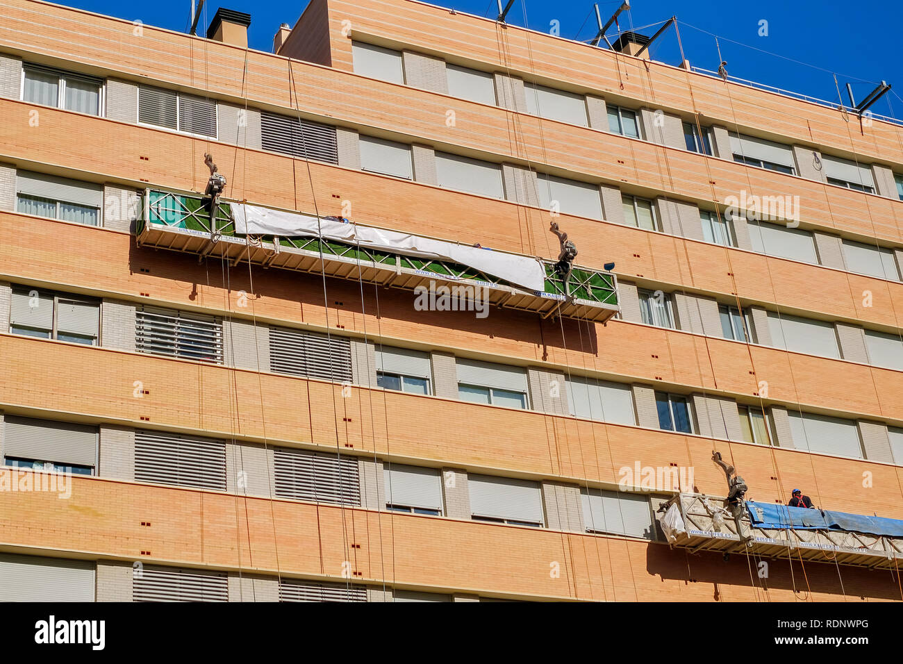 Arbeiter auf das äußere Gerüst Aufzug im Gebäude zu reparieren Stockfoto