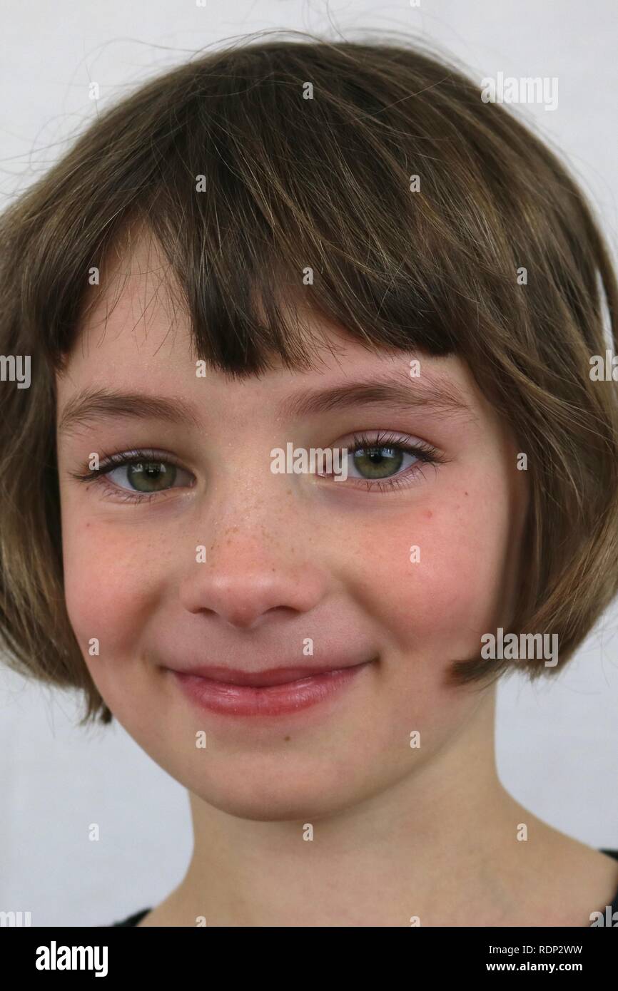 Porträt eines Green Eyed Girl mit einem schelmischen Grinsen Stockfoto