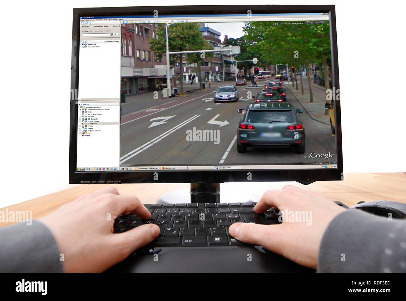 Person sitzen an einem Computer arbeiten mit Google Street View, Bildschirm und zeigt ein detailliertes Bild der Teil der Innenstadt von Stockfoto