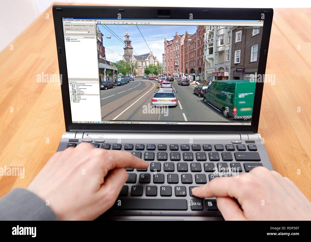 Person sitzen an einem Computer arbeiten mit Google Street View, Bildschirm und zeigt ein detailliertes Bild der Teil der Innenstadt von Stockfoto