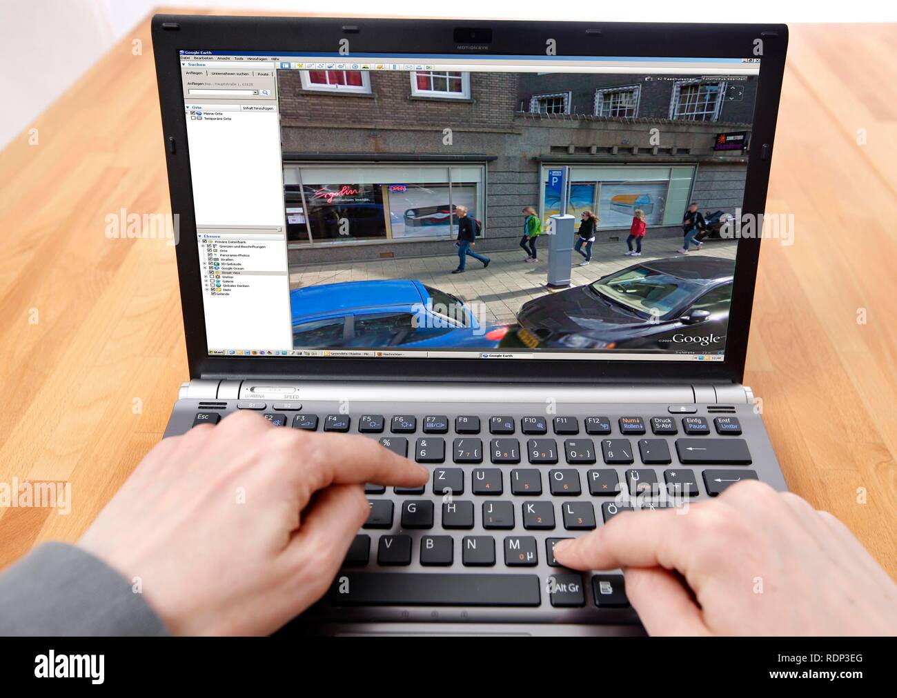 Person sitzen an einem Computer arbeiten mit Google Street View, Bildschirm und zeigt ein detailliertes Bild der Teil der Innenstadt von Stockfoto