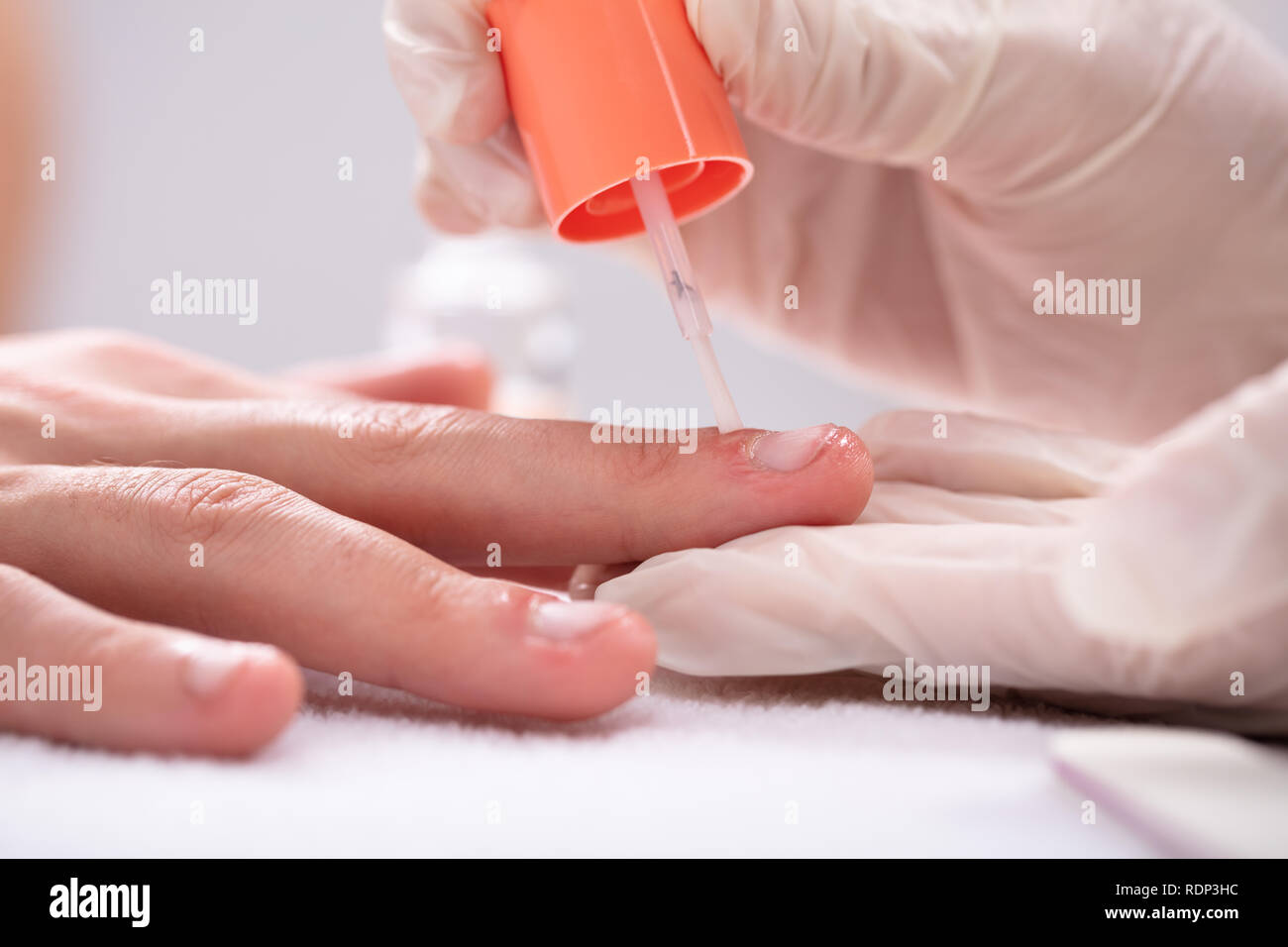 Close-up Kosmetikerin Anwendung Nagel Öl auf der Hand in Spa Stockfoto