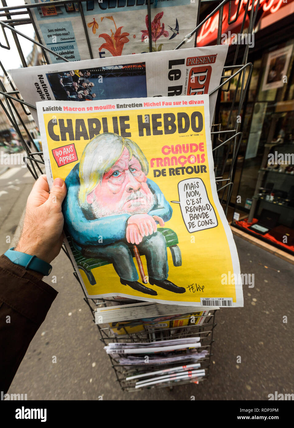 PARIS, Frankreich, 15. MÄRZ 2018: POV Mann hält Charlie Hebdo Zeitung mit Karikatur von Claude Francois Stockfoto