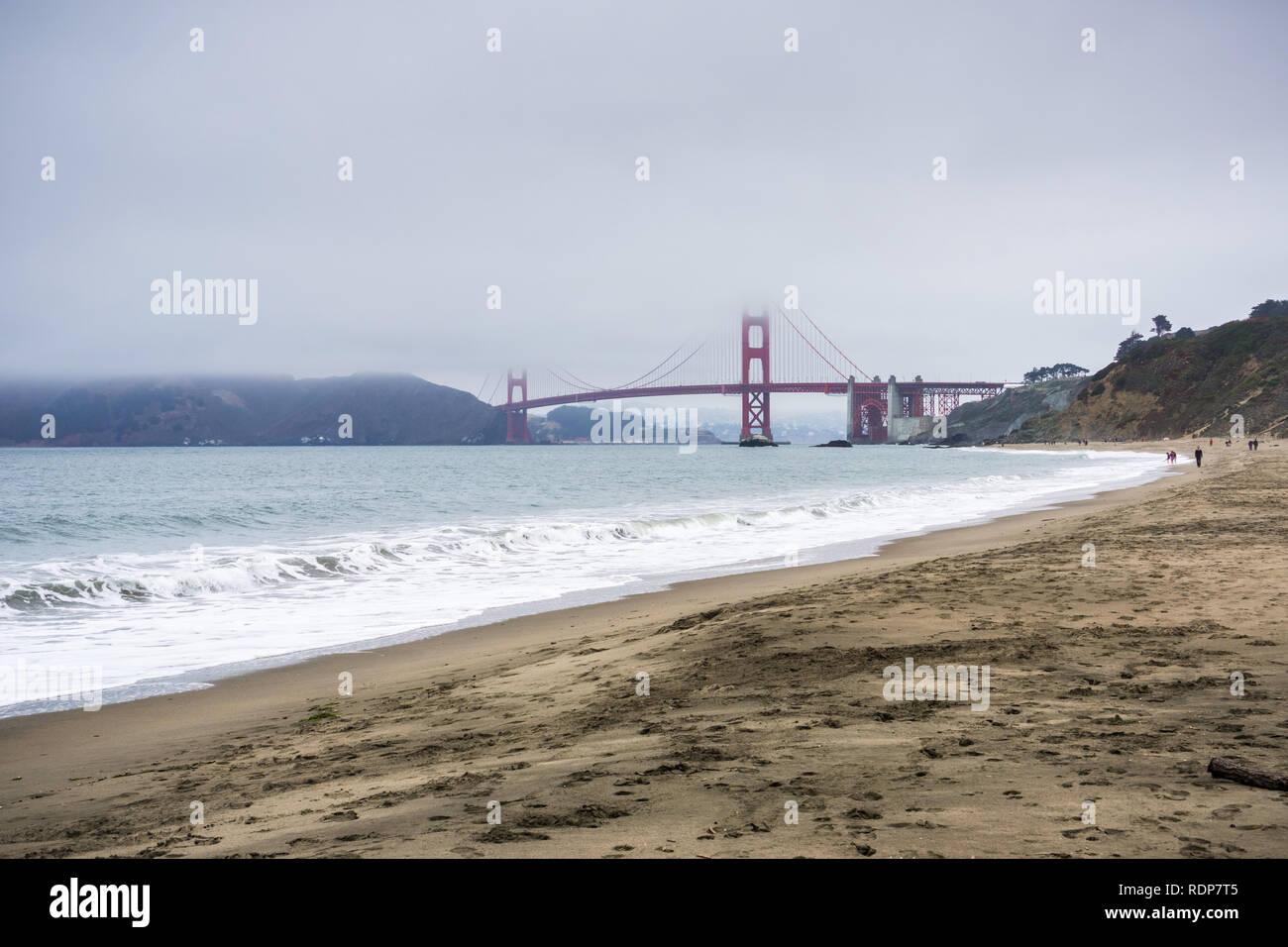 Menschen zu Fuß auf einem Sandstrand in der Nähe der Golden Gate Bridge, San Francisco, Kalifornien Stockfoto