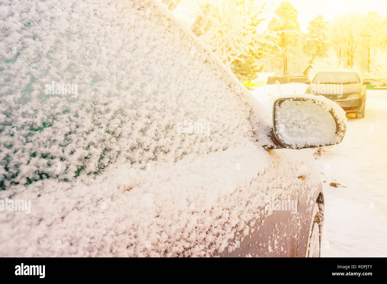 Auto im Schnee in einem Wohngebiet während extremer Schneefall geparkt. Das Konzept der Auswirkungen der saisonalen Faktoren auf das Metall des Autos. Stockfoto