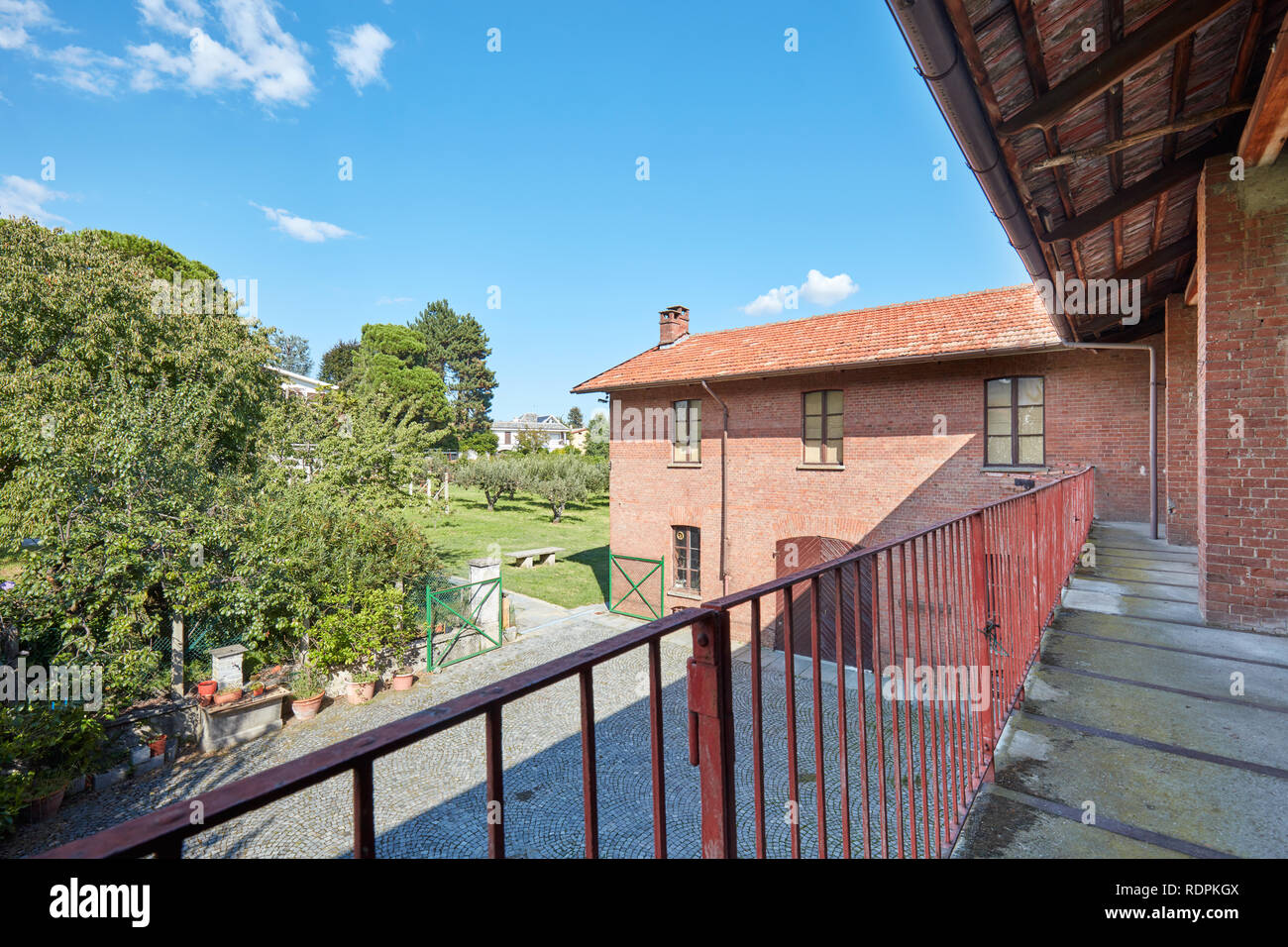 Altes Landhaus mit Terrasse und Mauerwerk an einem sonnigen Sommertag in Italien Stockfoto