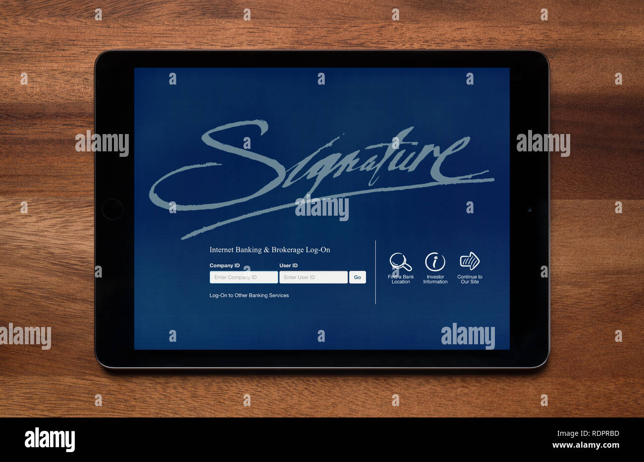 Die Website von Singature Bank gesehen auf einem iPad Tablet, der ruht auf einem Holztisch (nur redaktionelle Nutzung). Stockfoto