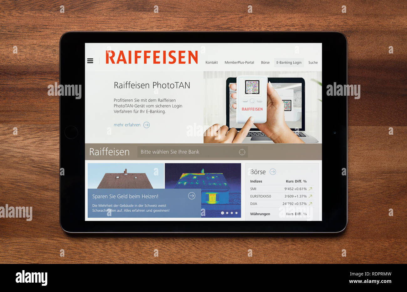 Die Website von Raiffeisen gesehen auf einem iPad Tablet, der ruht auf einem Holztisch (nur redaktionelle Nutzung). Stockfoto