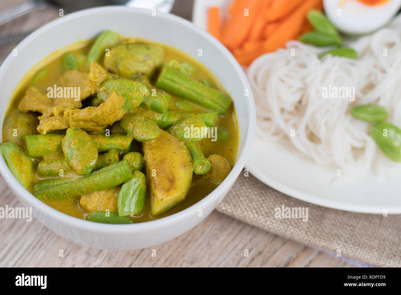 Thai Food spicy Schweinefleisch und Gemüse Parkia speciosa Curry mit Kokosmilch und Thai Reis Mehl Nudeln Stockfoto