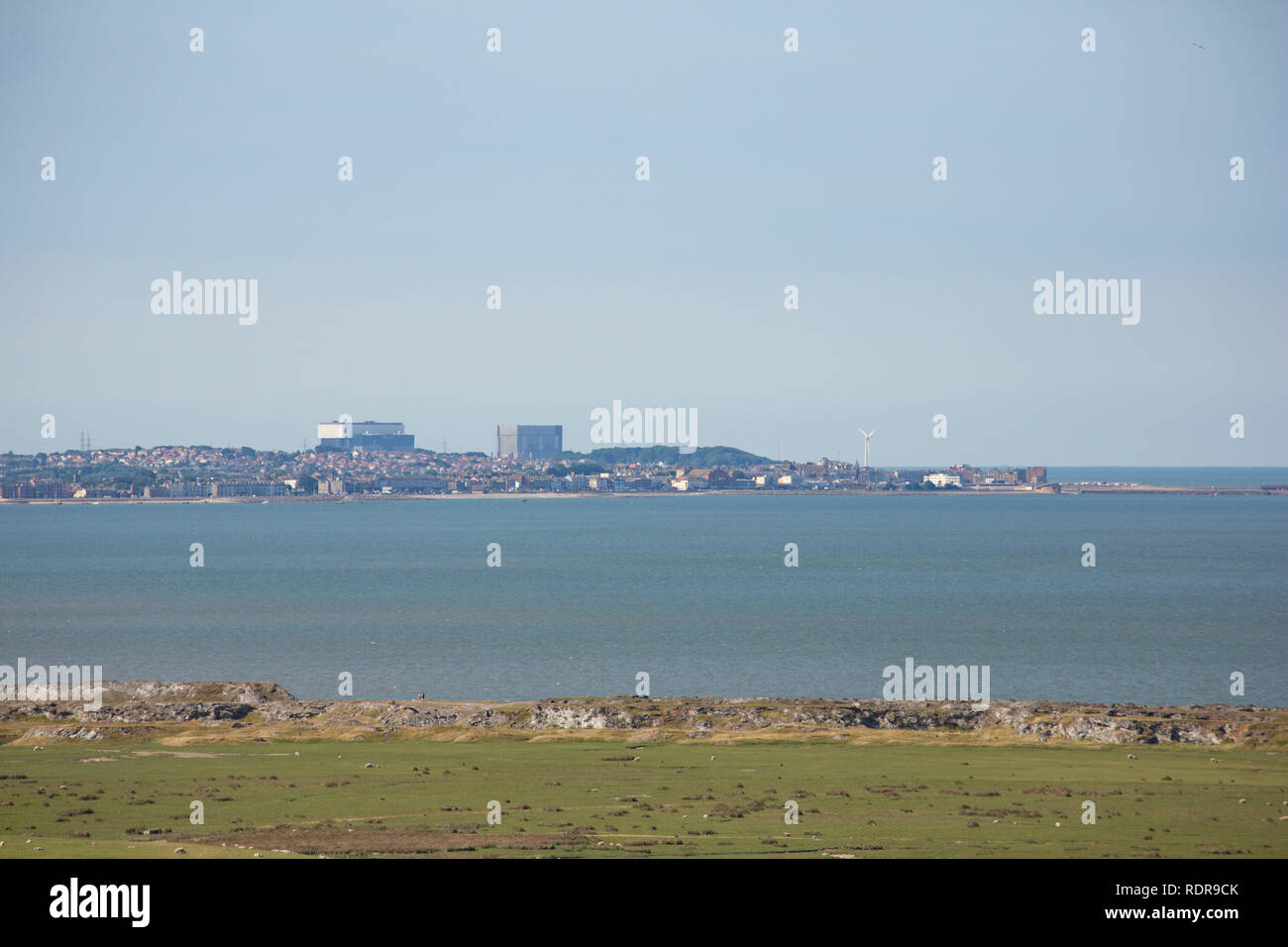 Ein Blick über die salzwiesen auf dem heißen und dunstige Tag aus Warton Crag von Heysham Kernkraftwerk mit Teil von Morecambe im Vordergrund. Lancashire Stockfoto