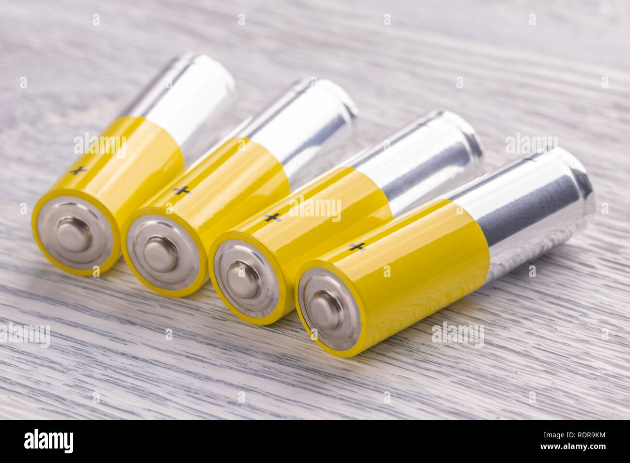 AA-Batterien liegen auf einer alten weißen Holztisch. Das Konzept der Lebensenergie finden Stockfoto