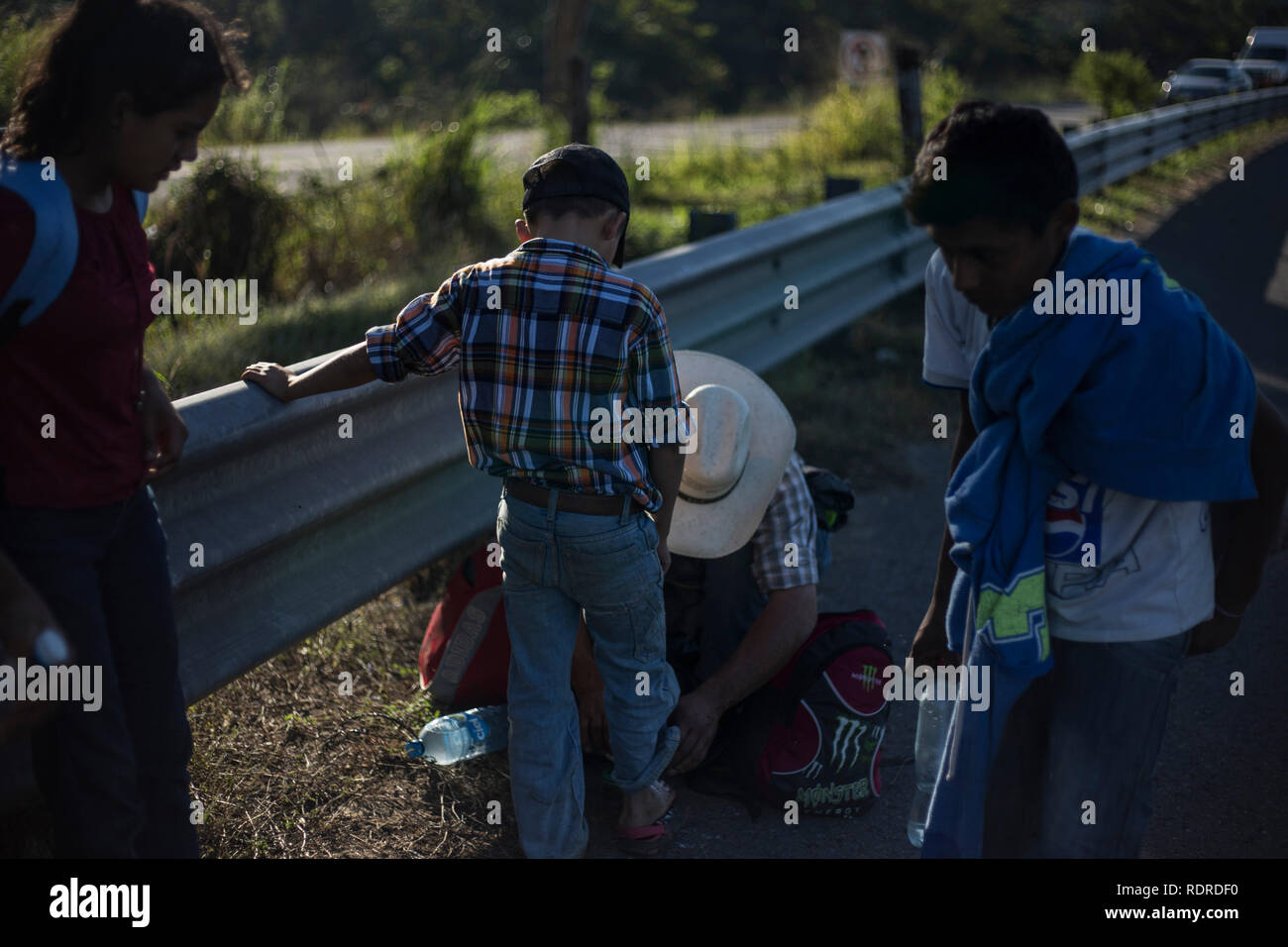 Ciudad Hidalgo, Mexiko. Jan, 2019 18. Ein Mann aus Honduras übernimmt Fußulzera seines Sohnes nach einem langen Marsch zu Fuß. Eine Gruppe von Migranten überquerten die Grenze zwischen Guatemala und Mexiko in Tecun Uman und zu Fuß durch Mexiko fort. Die Migranten Gewalt und Armut in ihren Heimatländern fliehen und Hoffnung zu Erreichen der Grenze der Vereinigten Staaten dort Asyl zu suchen. Credit: Victor Pena/dpa/Alamy leben Nachrichten Stockfoto