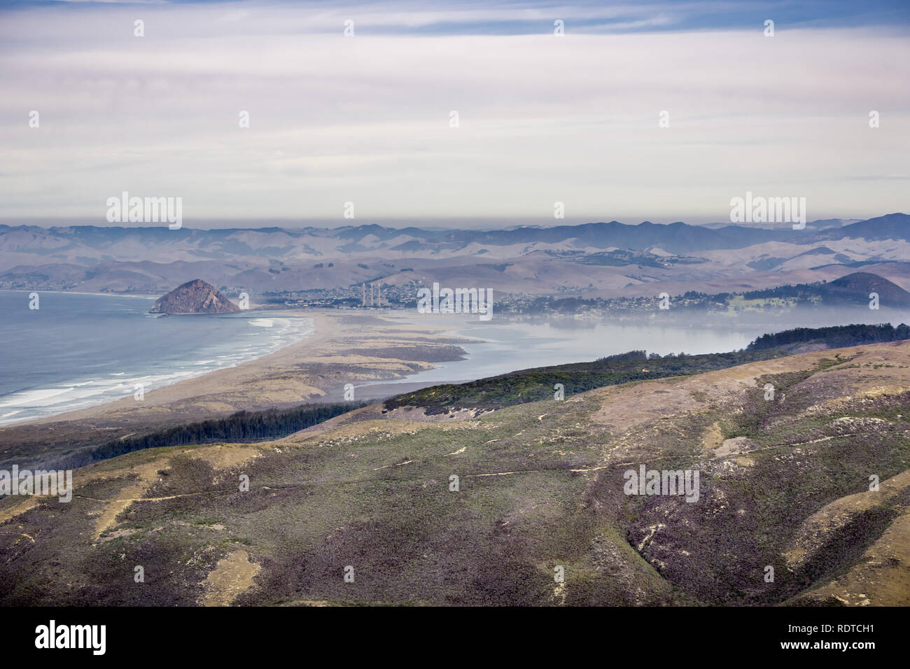 Blick in Richtung Morro Rock und Morro Bay State Park wie von Montana de Oro State Park gesehen; eine Schicht von Nebel bedeckt, Morro Bay, Kalifornien Stockfoto