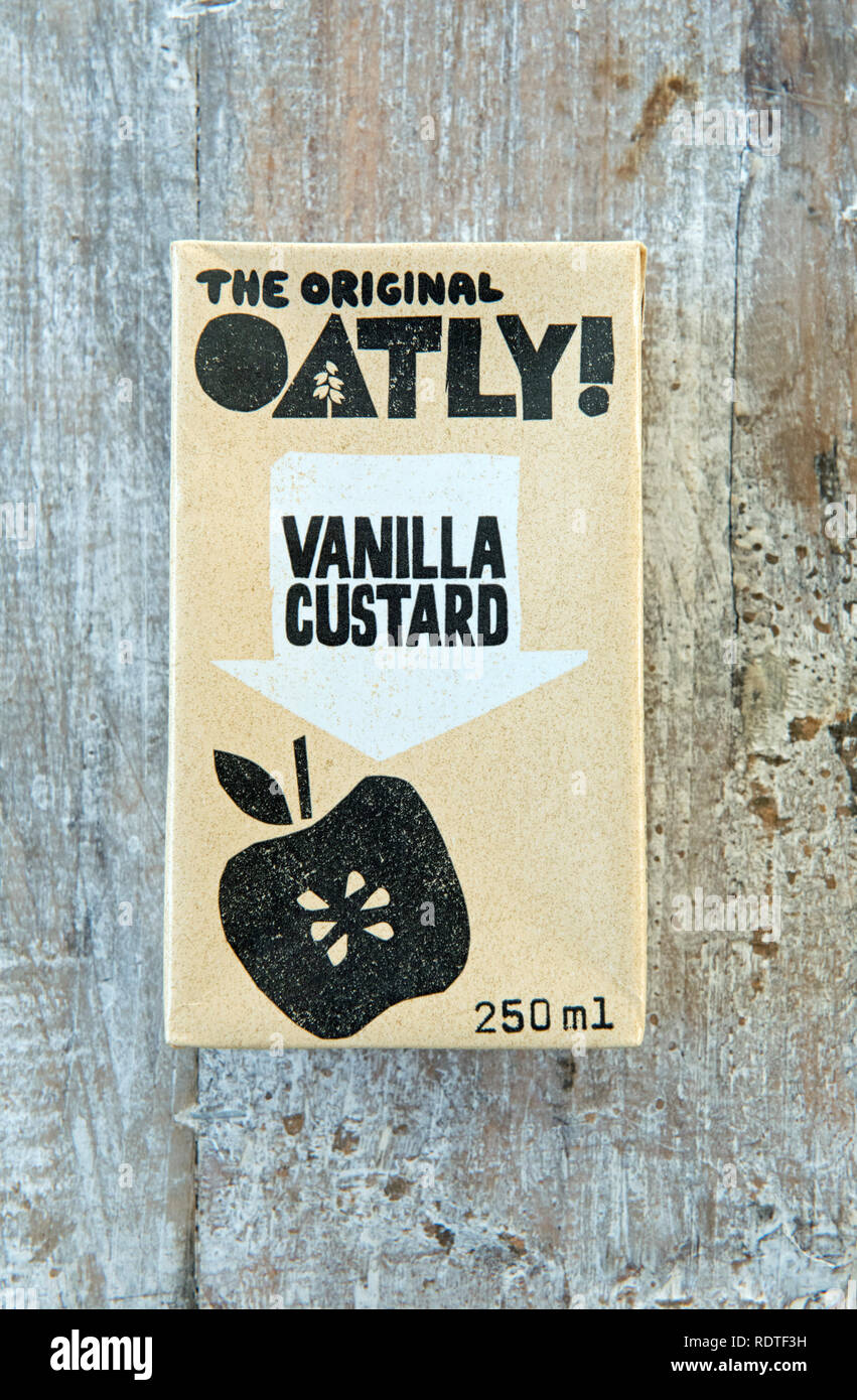Karton mit Otly Vegan Vanilla Custard auf einem Holztablett mit Distressed. Nur zur redaktionellen Verwendung Stockfoto