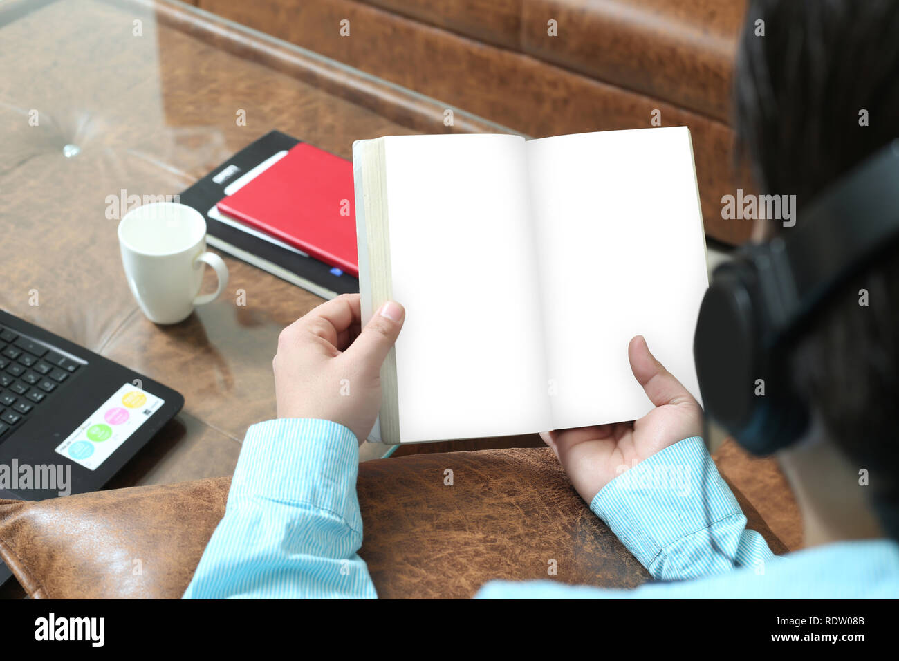Der Mensch ist zu lesen Buch und Musik mit Kopfhörer. Stockfoto